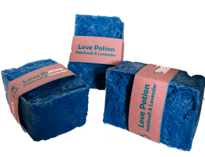 Three bars of Love Potion Patchouli and Lavender handmade soap by Bouncing Soaps with blue color and pink label on white background