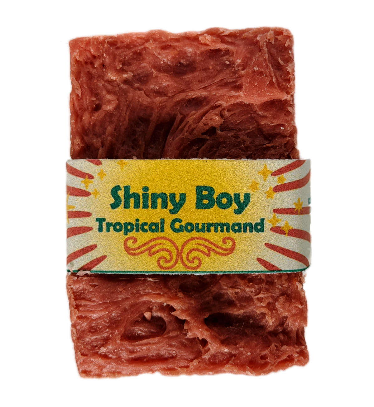 Coral-rose handmade soap bar with swirled rustic texture, wrapped in a vintage carnival-style yellow and cream band reading "Shiny Boy – Tropical Gourmand"