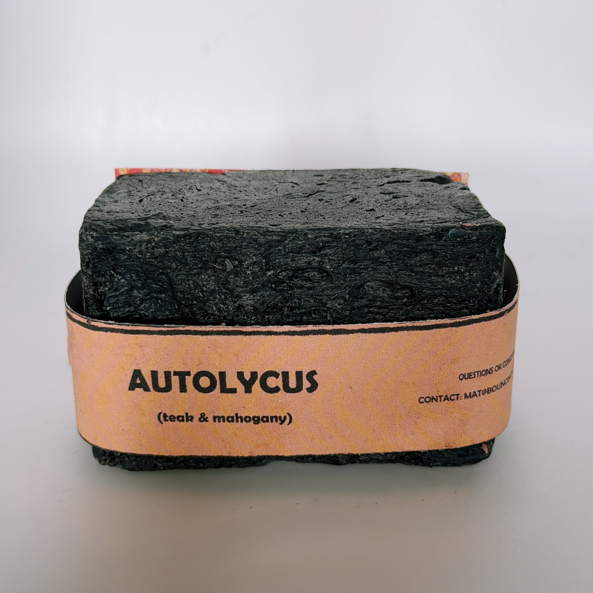 Single bar of Autolycus handmade soap by Bouncing Soaps showing dark black texture